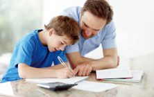 Father helping son with his schoolwork